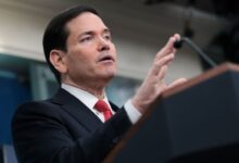 O secretário de Estado dos Estados Unidos, Marco Rubio, disse nesta terça-feira (5) que o status quo em Cuba é inaceitável, acrescentando que iriam abordar a questão, mas não hoje.nEm declarações à imprensa na Casa Branca, Rubio afirmou que os EUA também gostariam de dar mais ajuda a Cuba e distribuí-la por meio da Igreja.nNa semana passada, o presidente dos EUA, Donald Trump, brincou sobre a possibilidade do país “assumirem o controle” de Cuba imediatamente, sugerindo que forças militares poderiam avançar sobre o país no caminho de volta da guerra com o Irã.nn“Vamos terminar uma coisa primeiro, eu gosto de terminar o trabalho”, disse Trump sobre o conflito.n“Na volta do Irã, faremos isso. Teremos um dos nossos grandes — talvez o porta-aviões USS Abraham Lincoln, o maior do mundo. Vamos levá-lo até lá, parar a cerca de 100 jardas da costa, e eles vão dizer: muito obrigado, nós nos rendemos”, afirmou, referindo-se aos líderes cubanos.nEnquanto fazia esses comentários, Trump parecia sorrir de forma irônica, e a plateia riu. As declarações do presidente ocorrem depois de ele ter assinado, mais cedo na sexta-feira, uma ordem executiva ampliando as sanções dos EUA contra o governo cubano e seus aliados.nAs novas sanções foram o mais recente ataque da administração Trump contra Cuba, país que o presidente declarou repetidamente estar à beira do colapso.