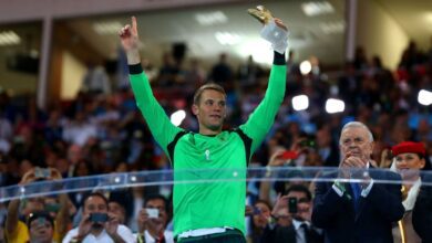 A posição de goleiro costuma concentrar, em poucos jogos, o peso de uma Copa do Mundo inteira. Desde 1994, quando a FIFA passou a oficializar o prêmio de melhor da posição, hoje chamado de Luva de Ouro, a lista de vencedores ajuda a contar a história recente dos Mundiais por um recorte decisivo.nA premiação, que antes levava o nome de Prêmio Yashin, nunca foi entregue antes do torneio dos Estados Unidos. A partir dali, cada edição teve um protagonista sob as traves, nem sempre o campeão, mas quase sempre decisivo.nnO primeiro da lista é Michel Preud'homme, destaque da Bélgica em 1994. Aos 35 anos, ele disputou apenas quatro jogos, mas manteve média de um gol sofrido por partida e ajudou a seleção a chegar às oitavas. Sua atuação marcou a estreia do prêmio e reforçou a ideia de que impacto pesa mais que longevidade no torneio curto.nQuatro anos depois, em casa, Fabien Barthez foi sinônimo de segurança. Sofreu apenas dois gols em sete partidas e terminou com cinco jogos sem ser vazado, peça-chave na campanha do título francês. A eficiência estatística, um gol a cada 342 minutos, ainda figura entre as melhores da história.nEm 2002, o prêmio foi para Oliver Kahn, talvez o exemplo mais claro de um goleiro carregando uma seleção. Com cinco jogos sem sofrer gols e apenas três bolas na rede em sete partidas, ele levou a Alemanha até a final e foi eleito também o melhor jogador do torneio, feito raríssimo para a posição.nA Copa de 2006 consolidou Gianluigi Buffon como referência de regularidade. Campeão com a Itália, sofreu apenas dois gols em toda a campanha, um deles contra, repetindo números de elite e reforçando a fama de liderança e consistência em jogos grandes.nO ciclo de domínio europeu seguiu em 2010 com Iker Casillas. Capitão da Espanha campeã, ele também sofreu só dois gols em sete jogos e protagonizou uma das defesas mais emblemáticas de finais de Copa, no duelo contra a Holanda.nQuatro anos depois, no Brasil, Manuel Neuer redefiniu o papel do goleiro moderno. Além das defesas, atuou como líbero, saindo da área para interceptar jogadas e participando da construção ofensiva. Foi peça tática central no título alemão.nEm 2018, na Rússia, o prêmio ficou com Thibaut Courtois. Mesmo com números menos impressionantes que alguns antecessores, seis gols sofridos, suas atuações em jogos decisivos, especialmente contra o Brasil, foram determinantes para o terceiro lugar da Bélgica.nJá em 2022, no Catar, Emiliano Martínez protagonizou um roteiro de alta tensão. Sofreu oito gols, mas brilhou nas disputas de pênaltis, com três defesas ao longo do mata-mata, e foi decisivo na final contra a França, garantindo o título argentino.nhttps://stories.cnnbrasil.com.br/esportes/como-a-copa-do-mundo-com-48-selecoes-muda-o-caminho-ate-o-titulo/