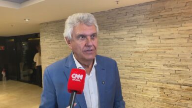 O pré-candidato à Presidência da República, Ronaldo Caiado (PSD), disse nesta segunda-feira (25), que os "problemas" que o também pré-candidato na disputa, Flávio Bolsonaro (PL), "tem que responder" estão não Brasil.n"Eu acho que os problemas que ele deveria dar ali a maior satisfação à população, eles estão aqui", afirmou o ex-governador de Goiás, quando questionado por jornalistas sobre a viagem do senador aos Estados Unidos.nnFlávio embarcou rumo ao país norte-americano na noite do último domingo (24), à espera de um encontro com o presidente Donald Trump. De acordo com apuração da CNN, há a previsão de um encontro entre os dois na próxima terça-feira (26), mas sem registro oficial, por enquanto, por parte da Casa Branca.nA viagem acontece pouco tempo depois do vazamento de mensagens que revelaram uma conversa entre o parlamentar e o banqueiro Daniel Vorcaro.nhttps://www.youtube.com/watch?v=DReWY2Z2H94nAinda sobre esse assunto, Caiado prometeu que, durante o período de campanha não sairá do Brasil.n"Esse fato específico da ida dele [Flávio Bolsonaro] aos Estados Unidos, eu não sei qual a pauta, se é que ele teve essa audiência marcada [com o presidente Donald Trump]. Eu realmente posso garantir que durante esse período todo, até a eleição, eu não vou sair do Brasil", completou.