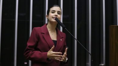 A relatora do projeto que criminaliza a misoginia, deputada Tabata Amaral (PSB-SP), mira a votação do texto em junho, antes do recesso parlamentar que começa na metade de julho. Para isso, a proposta será debatida em um grupo de trabalho, que será instalado na terça-feira (5).nSegundo Tabata, coordenadora do grupo, serão realizadas quatro audiências públicas para debater o texto e buscar consenso. O cronograma foi acordado pela deputada com o presidente da Câmara, Hugo Motta (Republicanos-PB). O calendário curto mira a aprovação antes do período eleitoral, quando o Congresso fica mais esvaziado.nnO projeto define a misoginia como “conduta que exteriorize ódio ou aversão às mulheres”. Aprovada no Senado em março, em votação unânime, a matéria inclui a misoginia entre os crimes de preconceito ou discriminação, previstos na Lei de Racismo. As penas variam de 2 a 5 anos de reclusão, além de multa.n"Essa violência começa com uma agressão verbal, passa pelo preconceito, pela discriminação, pelo ódio, que a gente está vendo. A gente tem um período apertado para fazer essa discussão. Foi até um compromisso nosso fazer a votação desse texto antes do recesso parlamentar, ali por junho", disse a relatora em vídeo gravado junto de Hugo.nO texto, no entanto, tem sido criticado por parte dos integrantes da oposição, que argumentam que a proposta pode prejudicar a liberdade de expressão. A proposta, no entanto, tem sinalização favorável de Hugo Motta. Ele tem reafirmado que o combate à violência contra a mulher é um tema prioritário para a Casa.nPara vencer a resistência ao texto, Tabata tem apostado no discurso de que o projeto não é partidário e mira uma questão de segurança. "O combate à violência não é de esquerda, não é de direita. É uma pauta de todos nós brasileiros", disse.nNo grupo de trabalho, a relatora quer conduzir o debate com a participação de deputadas, integrantes da sociedade civil organizada e juristas. O GT terá prazo de funcionamento de 45 dias e será composto por um representante de cada partido.n"Meu trabalho não é fazer barulho, é fazer maioria. É ouvir especialistas, movimentos, lideranças e principalmente dialogar com a população", afirmou Tabata em vídeo nas redes sociais.nhttps://www.youtube.com/watch?v=Cn7QvBgKBAM